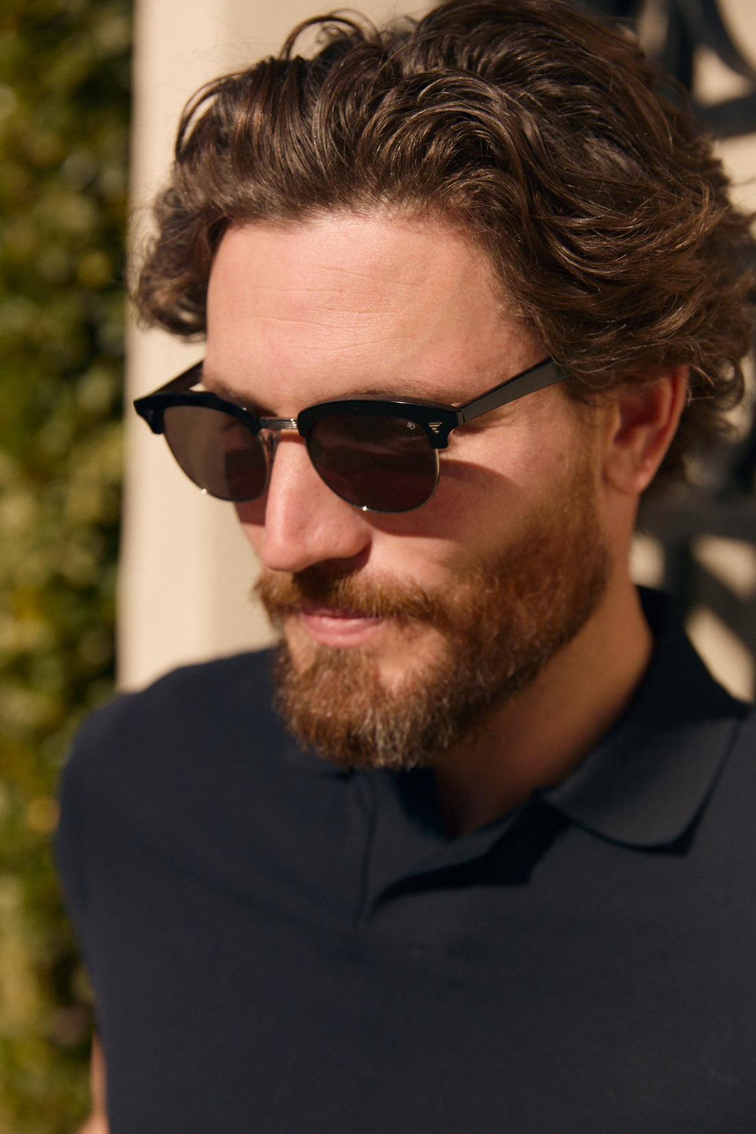 closeup of a man with a beard wearing browline sunglasses